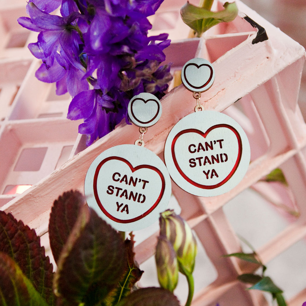 Candy & Kitsch candy heart earrings sits in a kitsch interior design in the variation ’can't stand ya' inspired by seinfeld
