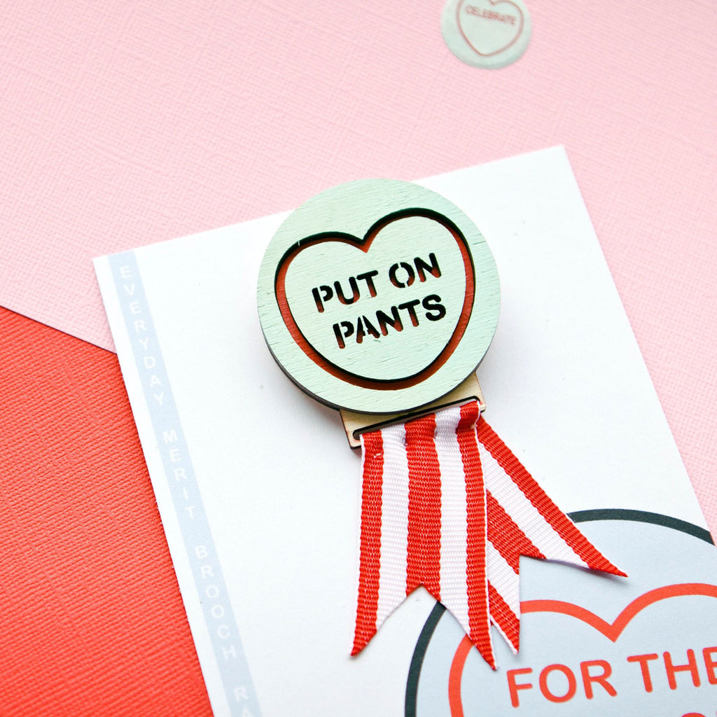 Candy & Kitsch motivational merit badge brooch saying 'put on pants' sits in a kitsch interior design aesthetic