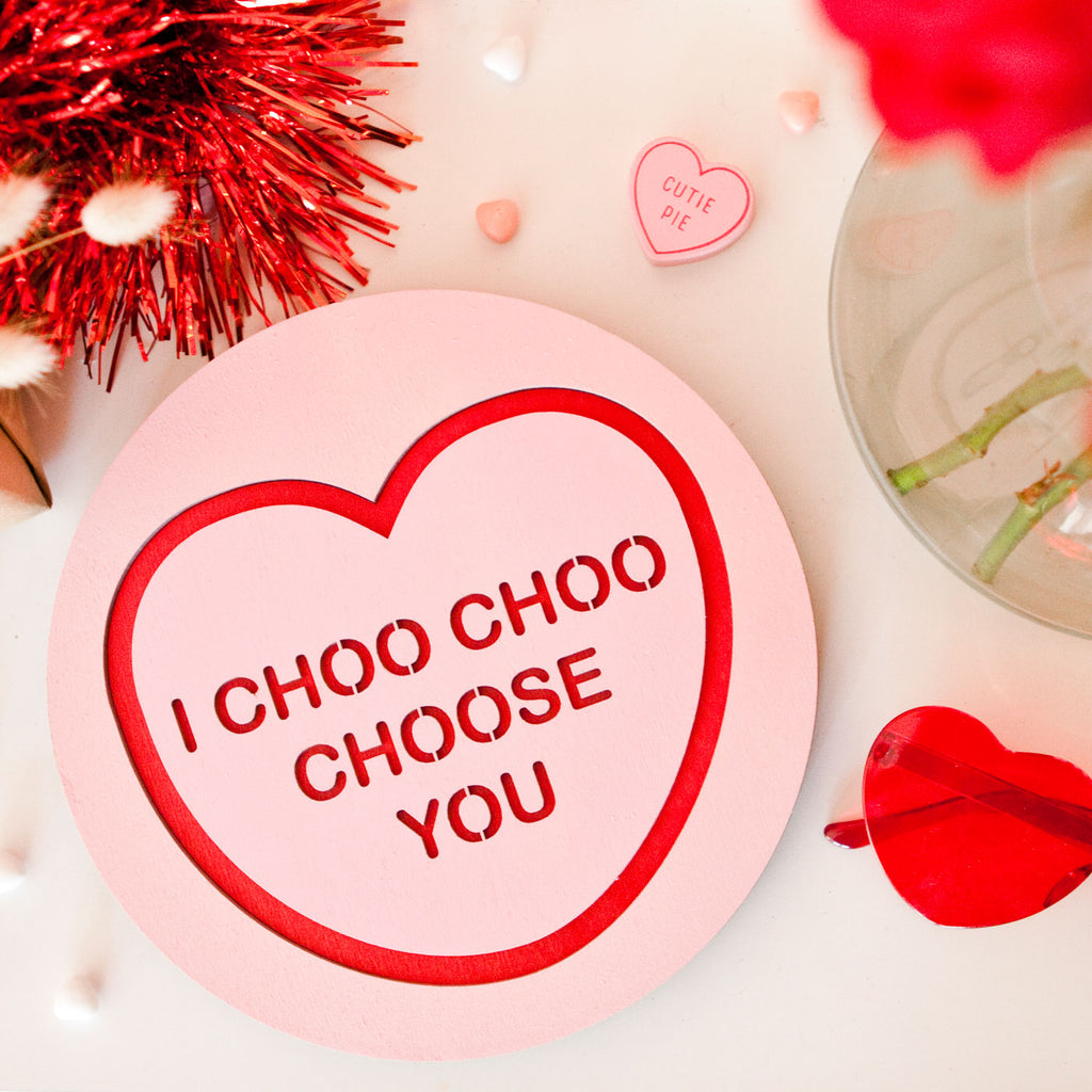 Candy & Kitsch candy heart wall hanging sits in a kitsch interior design in the variation ’i choo choo choose you' inspired by the simpsons
