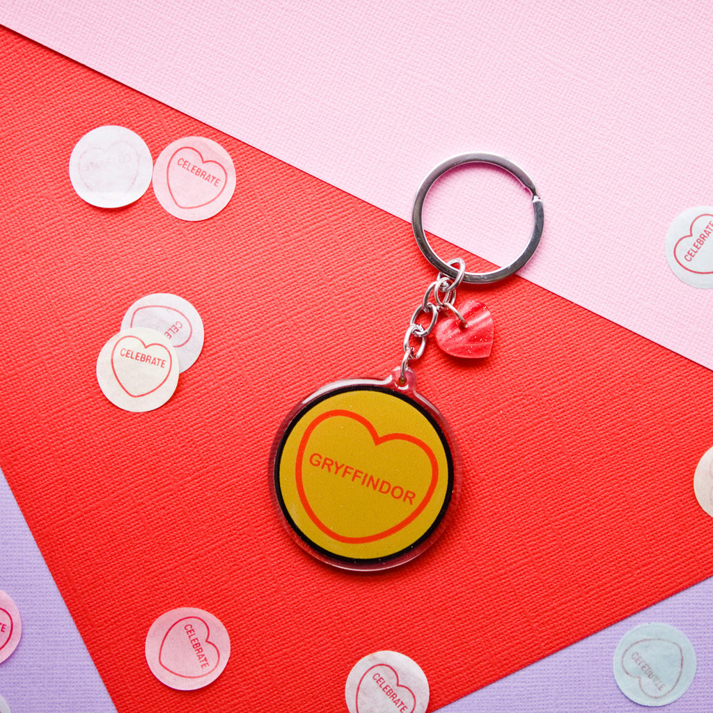 candy and kitsch harry potter candy hearts hogwarts house Gryffindor keyring sits in a colourful background with candy heart confetti