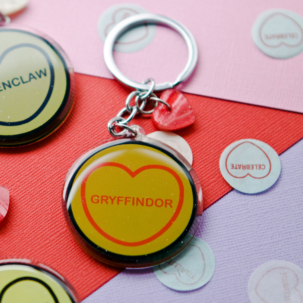 candy and kitsch harry potter candy hearts hogwarts house Gryffindor keyring sits in a colourful background with candy heart confetti