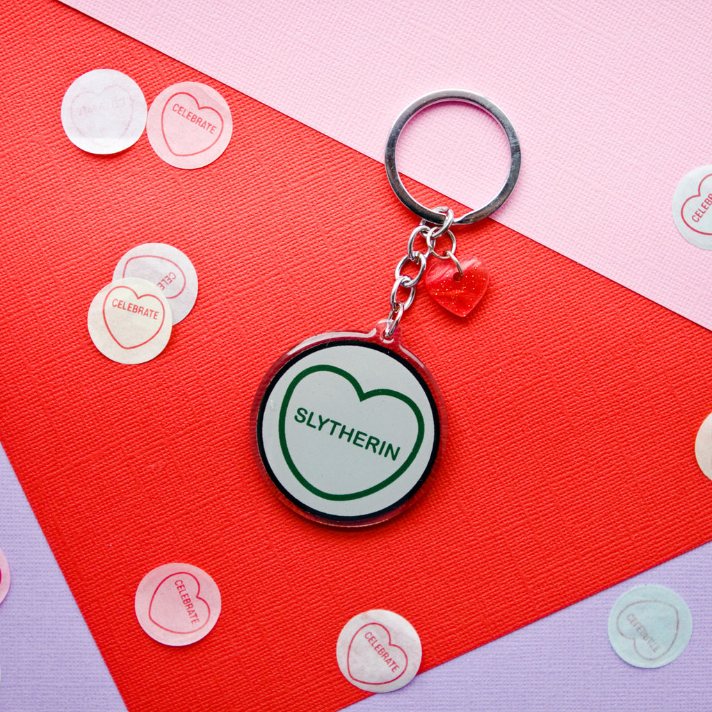 candy and kitsch harry potter candy hearts hogwarts house Slytherin keyring sits in a colourful background with candy heart confetti
