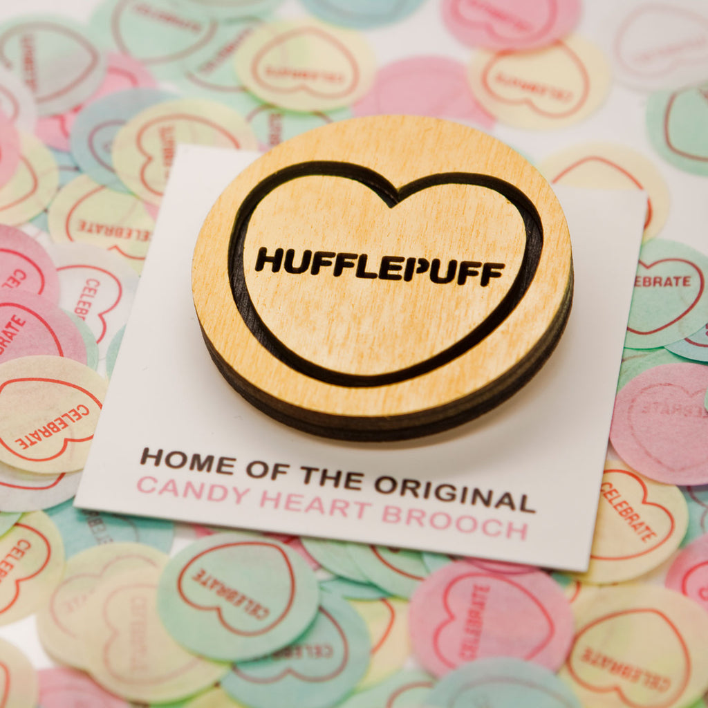 Candy & Kitsch Harry Potter Hogwarts House candy heart brooch sits in candy heart confetti in Hufflepuff variation