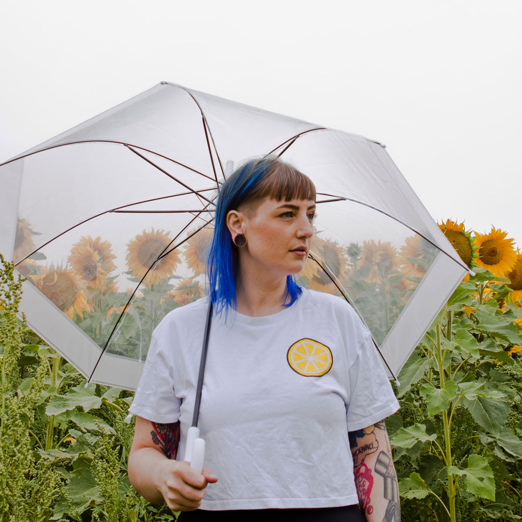 Candy & Kitsch founder Jess is wearing one of the 'easy peasy lemon squeezy' crop tops in a field of sunflowers